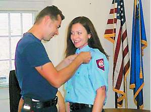 Firefighter Elizabeth Peto received her badge from her husband.